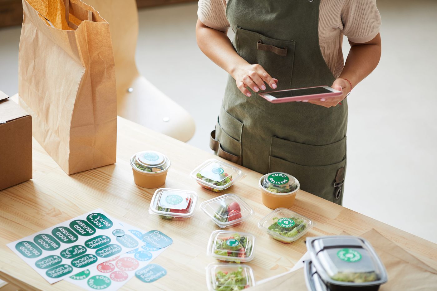 Manager preparing labeled salad containers for delivery
